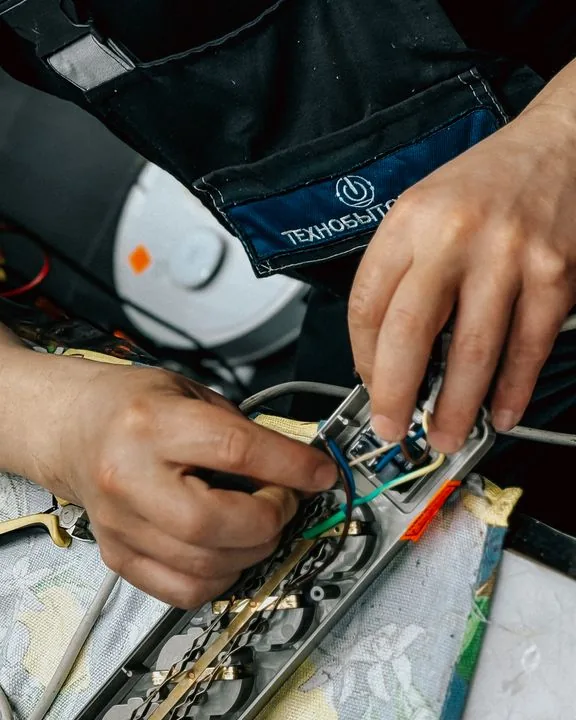 Tangan teknisi memeriksa komponen kelistrikan unit AC.